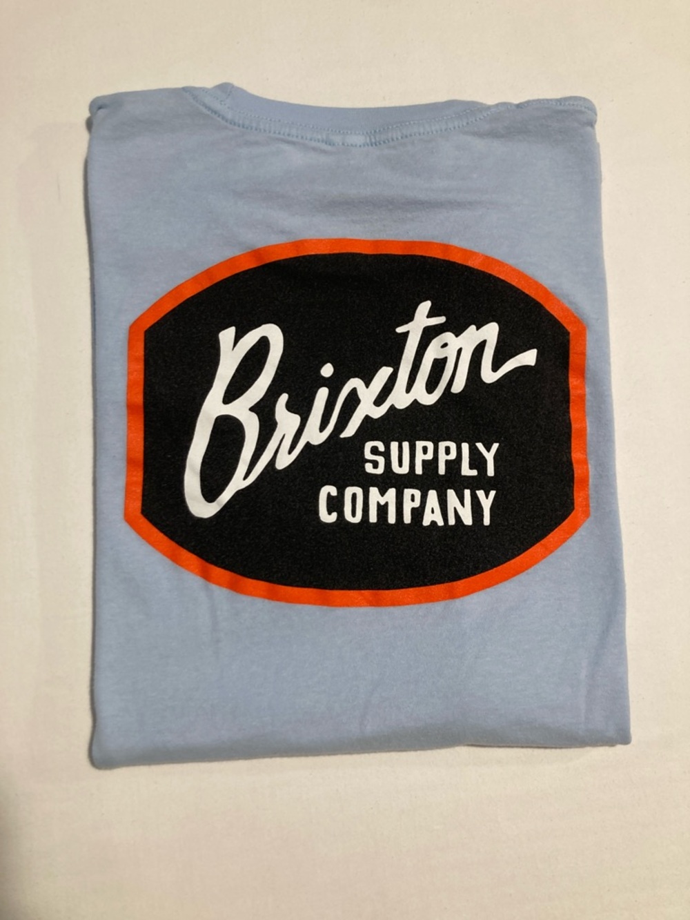 Brixton Sky Blue Short Sleeve Tee with Black and Orange Logo (G4)